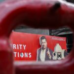 Man featured on a red advertisement board.