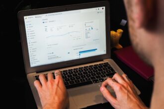 person using macbook pro on black table