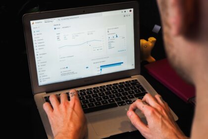 person using macbook pro on black table