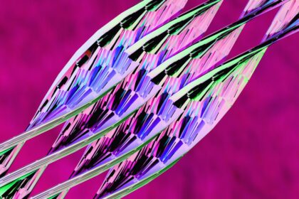 Abstract pattern of iridescent geometric shapes on magenta