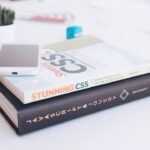 white smartphone on two softbound books