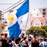 a crowd of people standing around a flag
