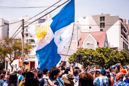 a crowd of people standing around a flag