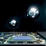 A circuit board with a central chip and reflective spheres.