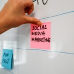 a hand is writing on a sticky note