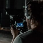 man in gray shirt holding camera