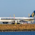 Singapore airlines airplane on tarmac with blue sky background