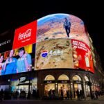Brightly lit billboards on a building at night