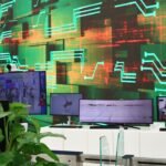 Digital screens display data on a circuit board background