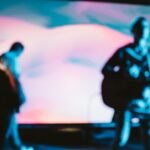 two men playing musical instrument on stage