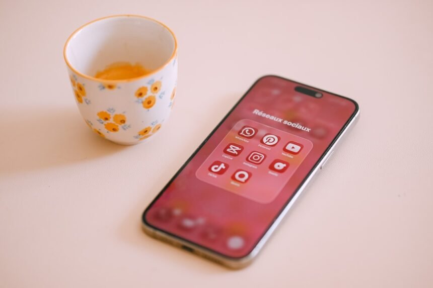 Smartphone with app icons next to a floral cup