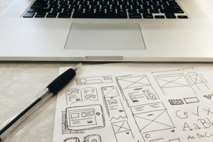 black pen on table beside grey laptop computer