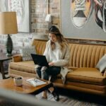 woman using laptop while sitting on chair